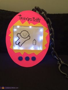 a pink and yellow photo frame with a chain attached to it that says thinkgotch