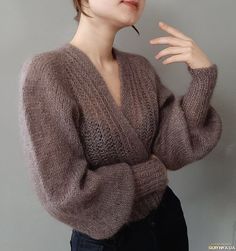 a woman with short hair wearing a brown sweater