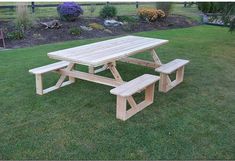 a picnic table with two benches in the grass