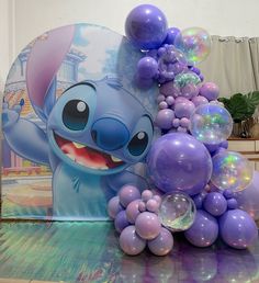 a bunch of balloons sitting on top of a table next to an image of stitch