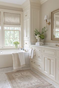 a large bathroom with white cabinets and bathtub in the center, along with a rug on the floor