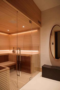 a sauna room with wooden walls and mirrors on the wall is lit by lights