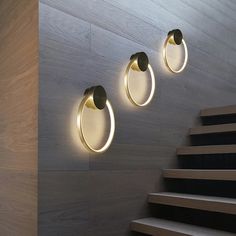 three lights on the wall above some stairs