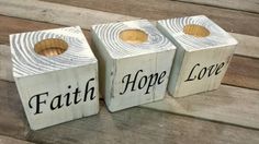 three wooden blocks with words that say faith, hope, love and toilet paper on them