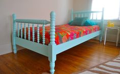 a bedroom with a blue bed and wooden floors