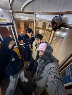 four young men standing on the inside of a bus