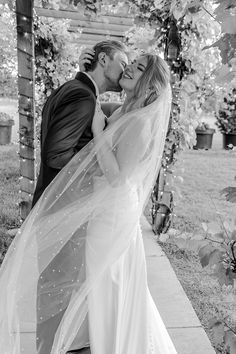 a bride and groom kissing under a veil