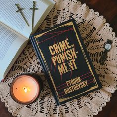 a book sitting on top of a doily next to a candle