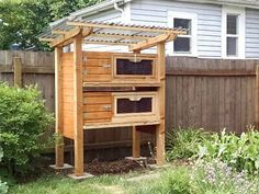 a wooden structure with two drawers in the middle of a yard next to a fence