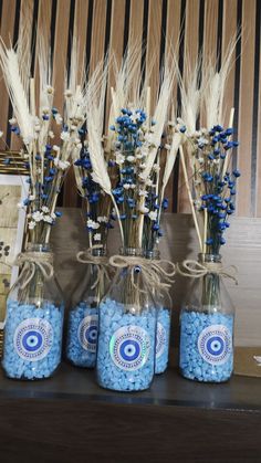 three glass jars filled with blue candies on top of a table