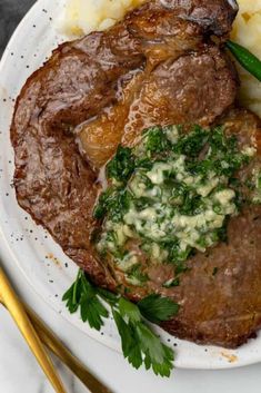 a white plate topped with steak and mashed potatoes