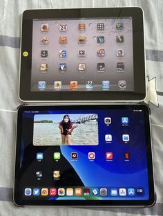 two tablets sitting side by side on top of a bed