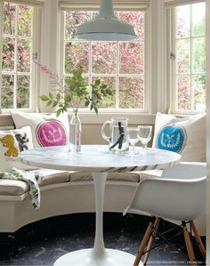 a white table sitting under a window in a living room