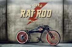 an old fashioned motorcycle is parked in front of a wall with the word rat rod on it