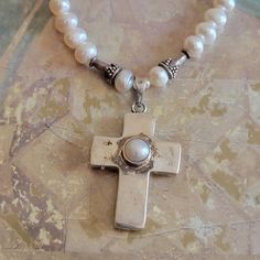 This is a vintage, sterling silver and pearl,  cross pendant on a pearl necklace with sterling beads and a sterling clasp. The pendant cannot come off of the necklace. This has tested positive for sterling. All sales are final.  The necklace measures a bit over 16  inches. The cross measures 39 mm x 22 mm across.   If you have a wish list or are looking for something specific, please ask. I may have exactly what you are looking for.  As always please convo me with any questions or concerns regarding this item or with any international shipping questions. Unfortunately I do not accept returns or grant refunds. All shipping fees include handling fees. If you would like to combine shipping costs for more than one item, I would be happy to do so if you convo me before purchase.  Purchasing my Silver Pearl Cross Pendant Necklace, Silver Pearl Necklace With Cross Pendant, Silver Cross Pendant Pearl Necklace As Gift, Silver Cross Pearl Pendant Necklace, Silver Pearl Necklace With Cross Pendant For Gift, Silver Cross Necklace With Pearl Drop, Spiritual Cross-shaped Pearl Necklace As Gift, Spiritual Cross Pearl Necklace Gift, Spiritual Cross Pearl Necklace As Gift