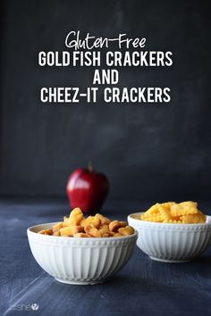 two white bowls filled with cheez - it crackers next to an apple