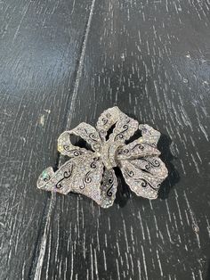 Here we have a beautiful vintage silver-colored metal brooch. Looks like a ribbon/bow.Shiney silver metal with black accents with amazing vivid iridescent glass stones. Unmarked. With a safety clasp. Very detailed metalwork. Measurements:3.25 inches across and 2.5 inches high. The largest stone is 1/4 inch. Weighs 1.5 ounce. Perfect for yourself or to give as a gift. Enjoy Free Shipping on All of my items to the Continental USA. (unless otherwise noted) All my items are Vintage or Antique and ke Victorian Silver Brooch For Evening, Ornate Silver Brooches For Evening, Silver Brooch With Decorative Bow, Silver Brooches With Decorative Bow, Silver Brooch With Decorative Bow For Evening, Silver Rhinestone Brooches For Gifts, Silver Rhinestone Brooches As Gifts, Silver Sparkling Brooches For Evening, Sparkling Silver Brooches For Evening