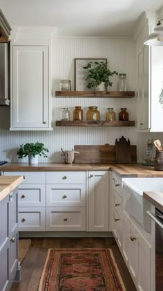 the kitchen is clean and ready for us to use it's white cabinetry