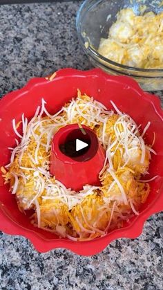 a red bowl filled with cheese and other food