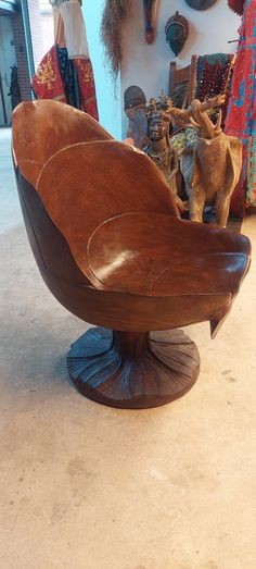 a wooden chair sitting on top of a floor next to a wall mounted deer head