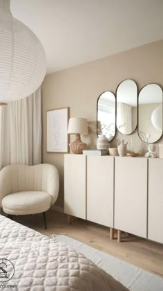 a white bed sitting in a bedroom next to a dresser and mirror on top of a wooden floor