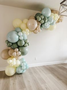 a bunch of balloons that are in the shape of a spiral on a wall next to a floor