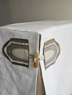 a close up of a white table cloth with some buttons on the side and an ironing board attached to it