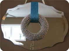 a mirror with a beaded ring hanging from it's side