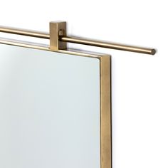 a close up of a mirror on a wall with a metal bar attached to it