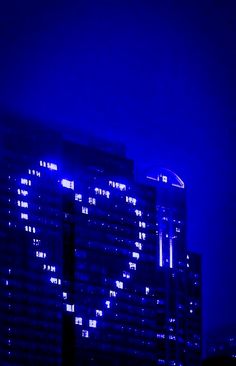 a very tall building lit up in the night sky with lights on it's sides