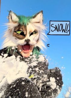 a cat that is standing in the snow with its mouth open and it's tongue out