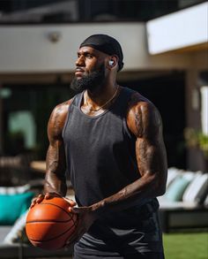 a man holding a basketball in his right hand and listening to headphones on the other