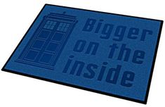 a blue door mat with the words bigger on the inside and a police call box