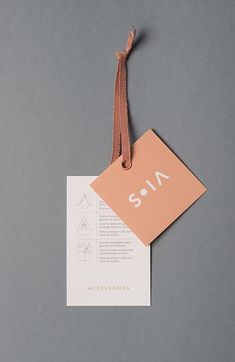 an orange tag with the word sala on it hanging from a brown string against a gray background