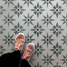 a person standing in front of a wall with green and white tiles on it's sides