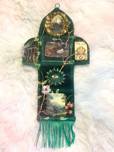 a green wall hanging with pictures and fringes on it's sides, in the shape of a fire hydrant