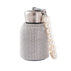 a silver and white bottle with pearls on it