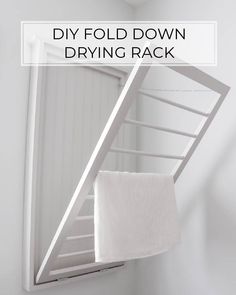 a white towel hanging on the side of a wall with text overlay that reads diy fold down drying rack