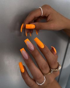 a woman's hand with orange and pink nails