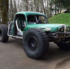 a large green truck parked on the side of a road