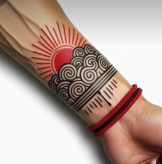 a person with a tattoo on their arm and wrist is holding up a red bracelet