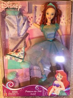 the little mermaid doll is in its box with her dress and tiara on it