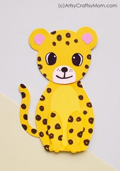 a paper cut out of a cheetah sitting on top of a white surface