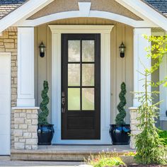 a front door with two planters on either side