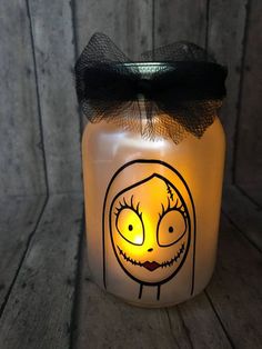 a lighted jar with a face drawn on it