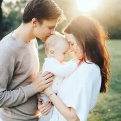 a man and woman holding a baby in their arms