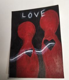 a piece of art with the words love painted on it and two red women facing each other