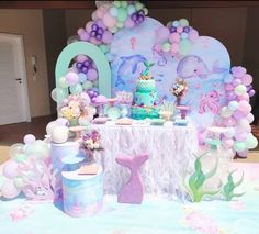 a table topped with a cake and balloons