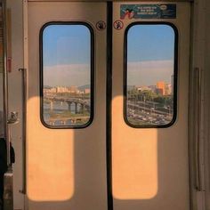 two double doors with the reflection of a bridge in them, on a train car