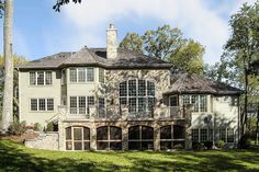 a large house with lots of windows on the front and side of it, surrounded by trees